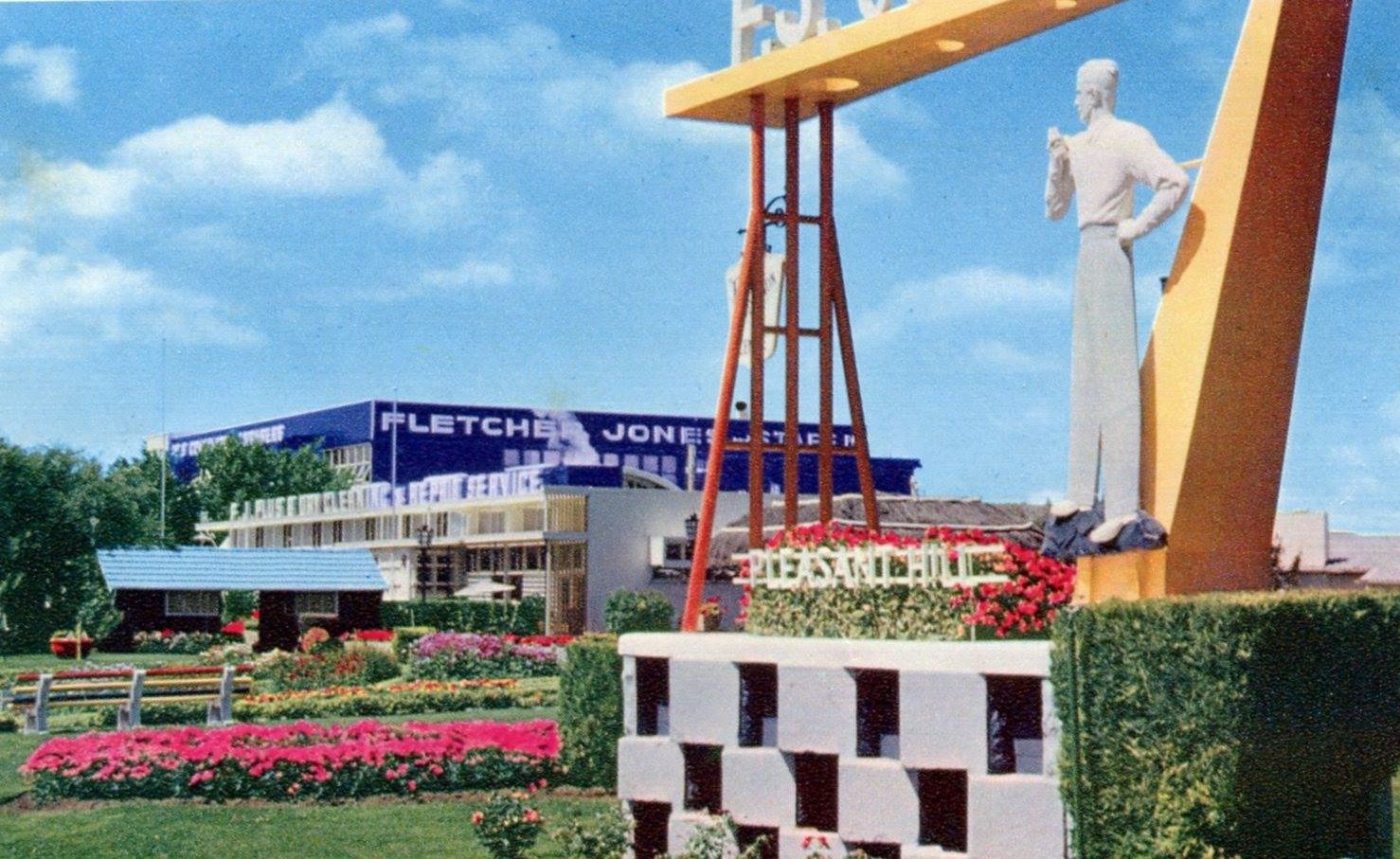 Pleasant Hill - the famous Plus 8 Man with the factory in the background. - both in their heyday.  The Plus 8 Man is very badly damaged and beyond repair.  Postcard from the 1960s