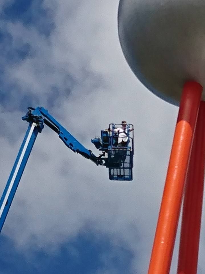 Julie Eagles going up in the boom lift with Matt Reeves on the final day of the makeover.  Photo: Lynny Mast