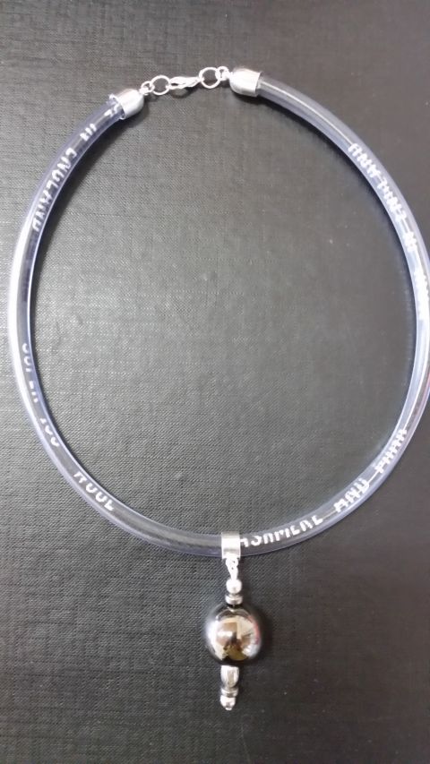 Silver Ball necklace ‘time capsule’ containing the embroidered selvedge of beautiful old FJ fabrics, often never seen.  Artist and Photo: Helen Bunyon.